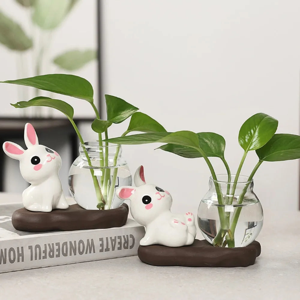 Bunny Glass Bud Vase: 05 sitting and sidelying bunny vases arranged together on a shelf
