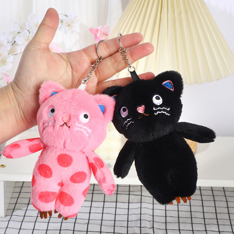 Black and pink cat plush bag charms shown side by side; sold separately
