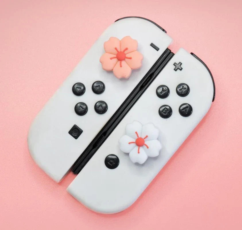 Sakura Flower Switch Thumb Grip Caps: Close view of pink and white sakura caps fitted to white controller sticks