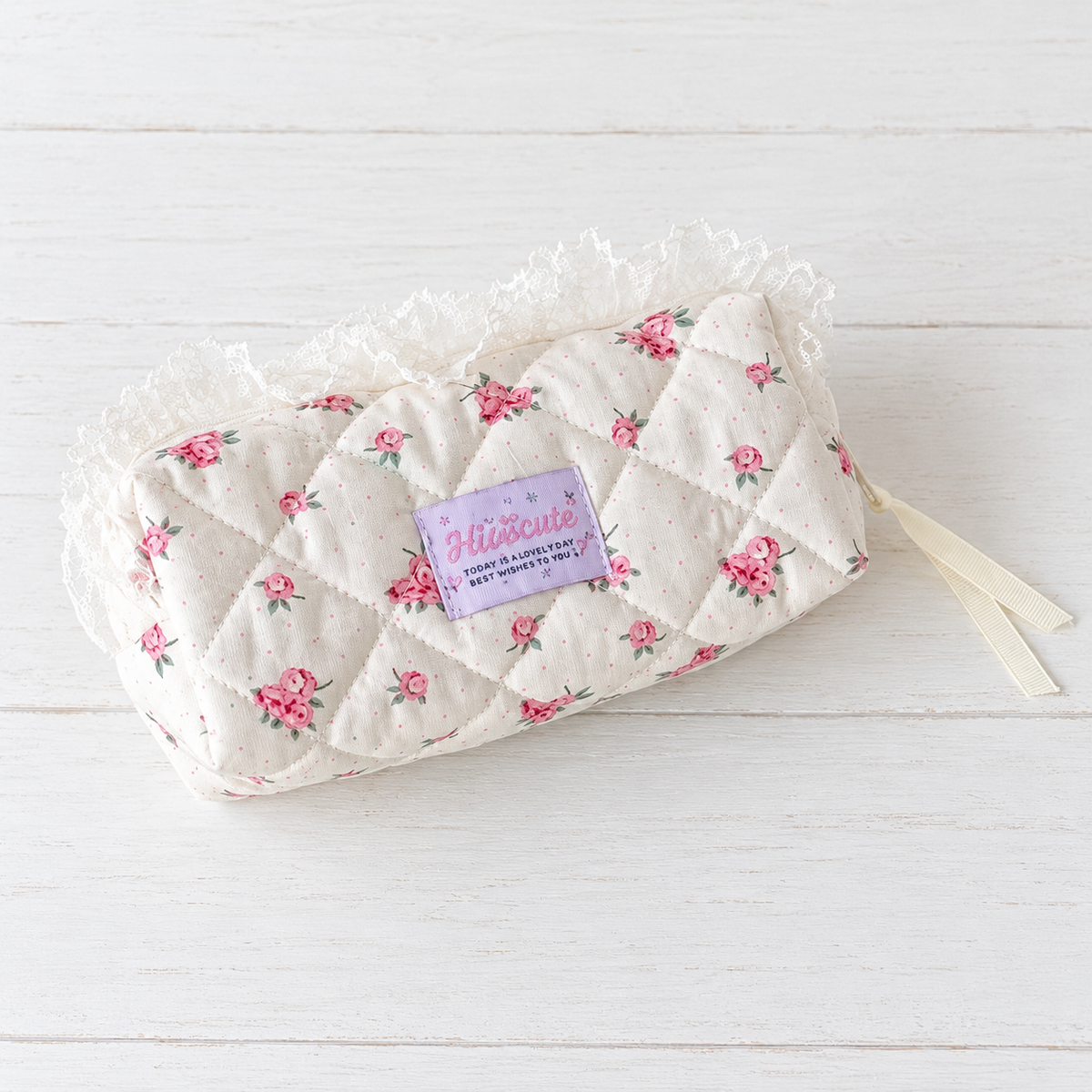 Floral quilted ruffle pencil case on white wood.