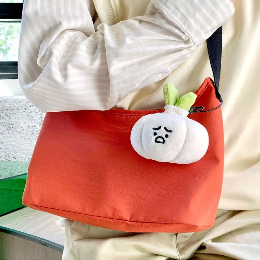 Grumpy Garlic Plush Keychain: Garlic plush keychain hanging from a red bag 04