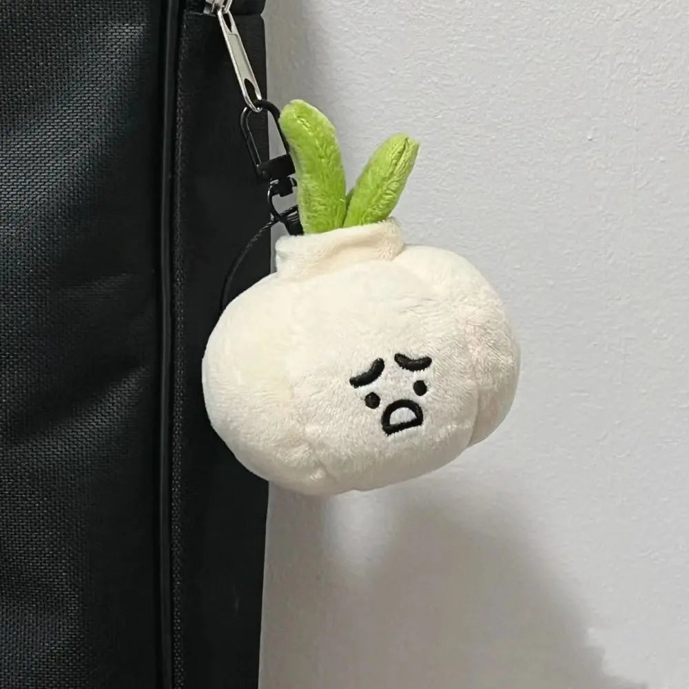 Grumpy Garlic Plush Keychain: White garlic keychain displayed on a dark bag 02