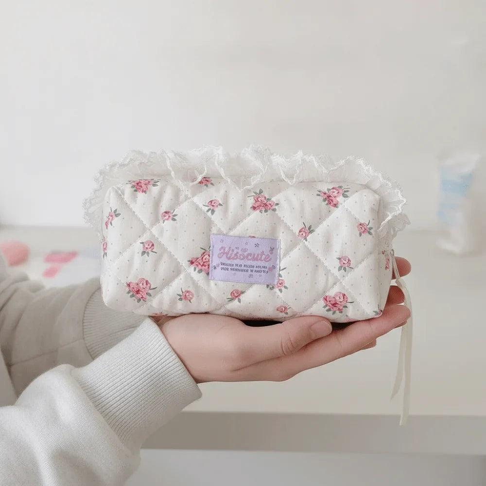 Quilted Ruffle Pencil Case: A white pencil pouch with a pink rose pattern rests on two 10