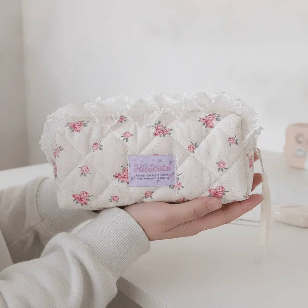 Quilted Ruffle Pencil Case: The floral ruffle pencil case is supported in one hand with a 15