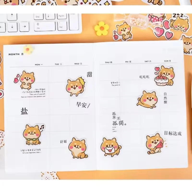 Rosy Puppy Sticker Box: Cute puppy stickers decorating a monthly planner on an orange desk