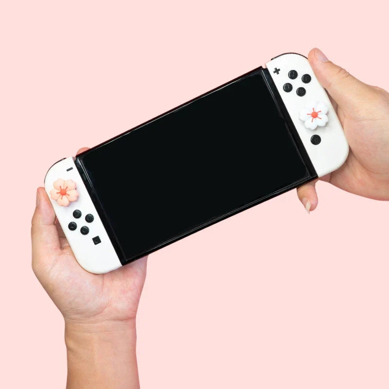 Sakura Flower Switch Thumb Grip Caps: Sakura flower thumb grip caps on a handheld console